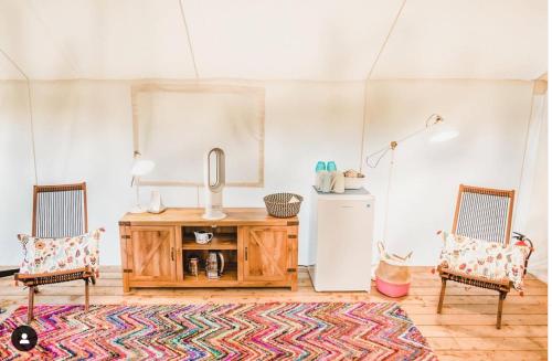 a living room with two chairs and a wooden table at Haida Gwaii Glamping in Tlell