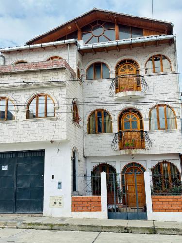 a white brick building with a lot of windows at Rajutuna Inn in Huaraz
