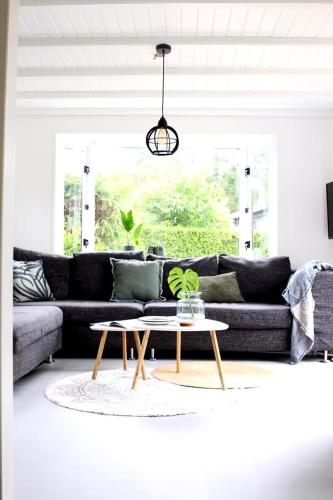 a living room with a couch and a coffee table at Cozy cottage with nice wood stove and veranda in Putten