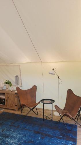 a room with two chairs and a table in a tent at Haida Gwaii Glamping in Tlell