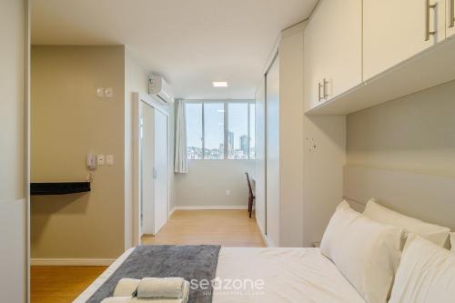 Un dormitorio con una cama grande y una ventana grande. en Apto en cond. con piscina en Blumenau – PEM1301, en Blumenau