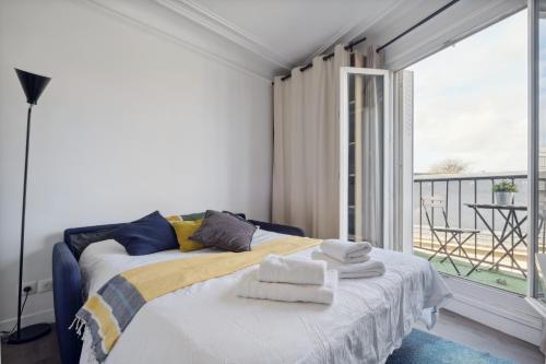 une chambre avec un lit avec des serviettes dessus dans l'établissement Amazing view apartment in heart of Paris, à Paris