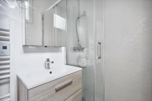 une salle de bain blanche avec un lavabo et une douche dans l'établissement Amazing view apartment in heart of Paris, à Paris