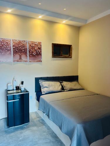 a bedroom with a large bed and a table at Margarida 04 in Monte das Gameleiras