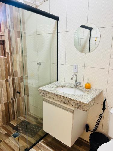 a bathroom with a sink and a shower at Margarida 04 in Monte das Gameleiras