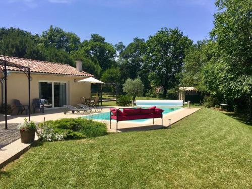 une cour arrière avec une piscine et une maison dans l'établissement Le Créolia, à Saint-Vincent-de-Barrès