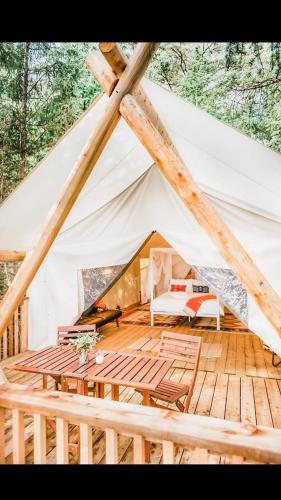 a tent with a wooden floor and a table at Haida Gwaii Glamping in Tlell