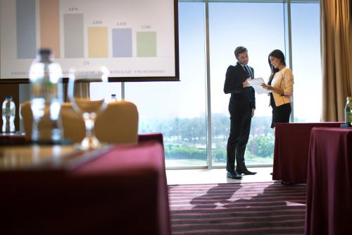 a man and a woman standing in a conference room at Park Arjaan by Rotana, Abu Dhabi in Abu Dhabi