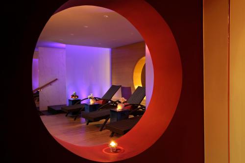 a room with tables and chairs and a mirror at Park Arjaan by Rotana, Abu Dhabi in Abu Dhabi