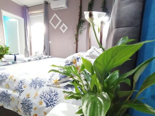 a bedroom with a bed and a plant at Dimora Bed and Breakfast in San Gavino Monreale