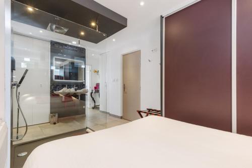 une chambre avec un lit et une porte coulissante en verre dans l'établissement Naturisme Port ambonne, au Cap d'Agde