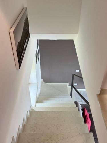 a staircase in a house with white walls and red pillows at Ca' Campitol in Torri del Benaco