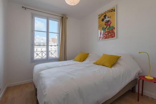 une chambre avec un lit blanc et une fenêtre dans l'établissement Toscane Garonne Disneyland Apartment BMYGUEST, à Serris