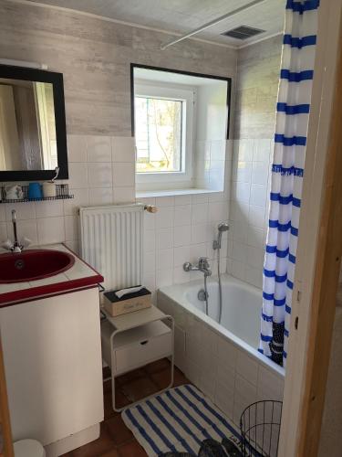 une salle de bain avec un lavabo et une baignoire dans l'établissement Maison familiale à la campagne, à Préaux