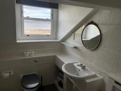 a bathroom with a sink and a mirror and a window at The Wildings Hotel & Tudno's Restaurant in Llandudno
