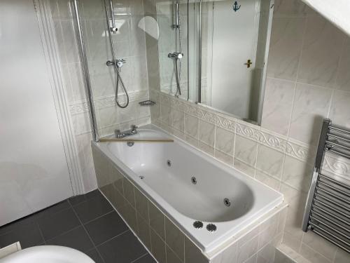 a bathroom with a tub and a shower and a toilet at The Wildings Hotel & Tudno's Restaurant in Llandudno