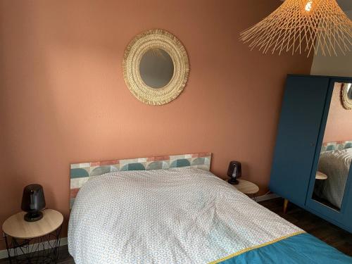 une chambre avec un lit et un miroir dans l'établissement Le Galion, à Saint-Hilaire-de-Riez