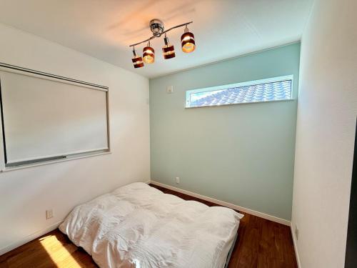 a bedroom with a bed and a window in it at Hadano City Hideaway 6min Walk to Station EasyAccess to Hakone & Shonan in Hadano