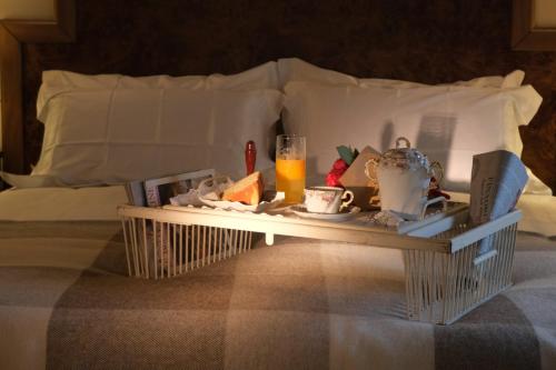 a tray with food and drinks on a bed at Residenza Paulonia in Volta Mantovana