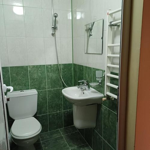 a bathroom with a toilet and a sink at Enjoy Guest House in Golden Sands