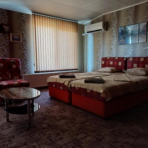 a bedroom with a bed and a chair and a table at Enjoy Guest House in Golden Sands