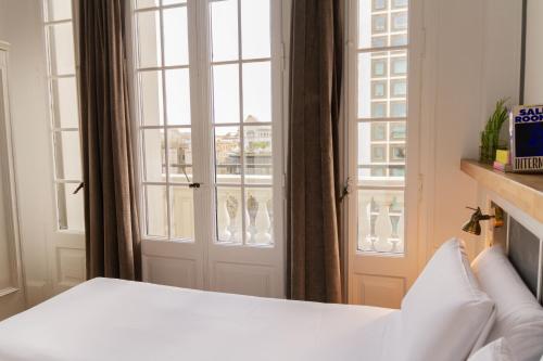 a bedroom with a bed and a window at Casa Gracia in Barcelona