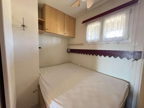 une petite pièce avec un lit et une fenêtre dans l'établissement Appartement T2 climatisé, terrasse, centre-ville - FR-1-308-54, au Lavandou