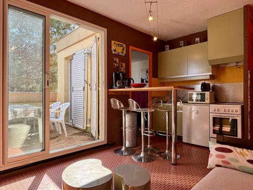 - une cuisine avec une table, des chaises et un comptoir dans l'établissement Appartement 2 pièces avec garage privé et terrasse, à 80 m de la mer, classé 2 étoiles, Argelès-sur-Mer - FR-1-225-82, à Argelès-sur-Mer