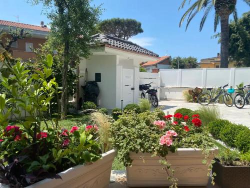 a garden with flowers in pots in front of a house at Fregene Tiny house close to the sea in Fregene