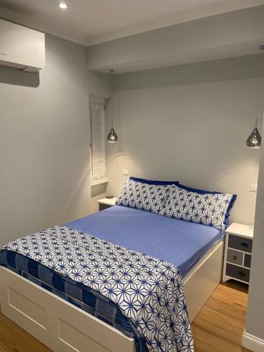 a bedroom with a bed with a blue comforter at Fregene Tiny house close to the sea in Fregene