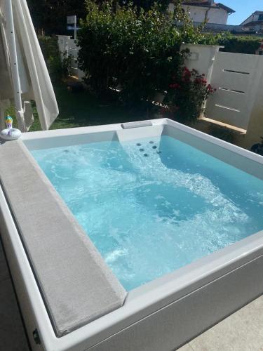 a hot tub with blue water in a backyard at Fregene Tiny house close to the sea in Fregene