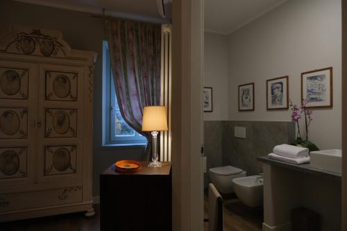 a bathroom with a sink and a toilet and a lamp at Residenza Paulonia in Volta Mantovana