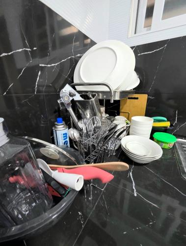 a counter top with dishes and utensils on it at Mamadear's Bed & Breakfast in Suizo