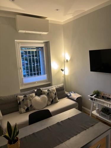 a living room with a couch with a heart pillow at Fregene Tiny house close to the sea in Fregene