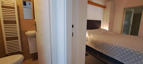 a small bedroom with a bed and a toilet at Tomcat in Zagreb