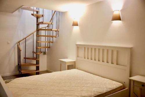 une chambre avec un lit et un escalier en colimaçon dans l'établissement MAISON centre de Cannes 4 couchages, à Cannes