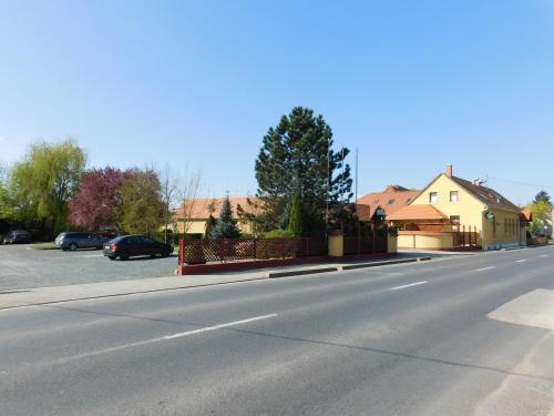 an empty street with cars parked on the side of the road at Berki Vendéglő és Hotel in Körmend