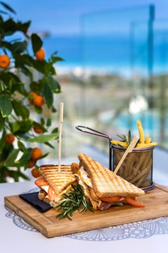 a sandwich on a cutting board on a table at Hotel In Excelsis in Novalja