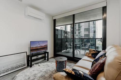 a living room with a couch and a tv at Town Centre Cozy 2 Bed 1 Bath with Free Parking in Belconnen