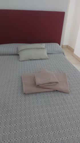 una cama con dos almohadas encima en Alojamientos en Curuzu Cuatia, en Curuzú Cuatiá
