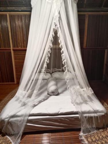 a white bed with a canopy in a room at Mares Homestay-Raja Ampat in Fam