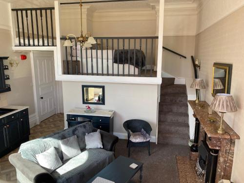 a living room with a couch and a staircase at Bellfield Country Suites in Masham
