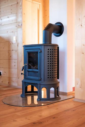 a blue stove sitting on top of a floor at Feriendorf Koralpe Chalet Speik XL 27 in St. Gertraud