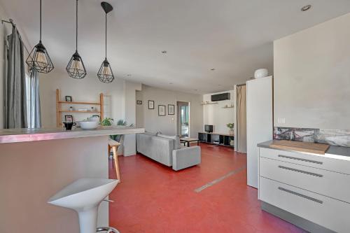 Il comprend une cuisine et un salon avec un sol rouge. dans l'établissement Le 33 - Clim - Free parking - Wi-Fi, à Avignon