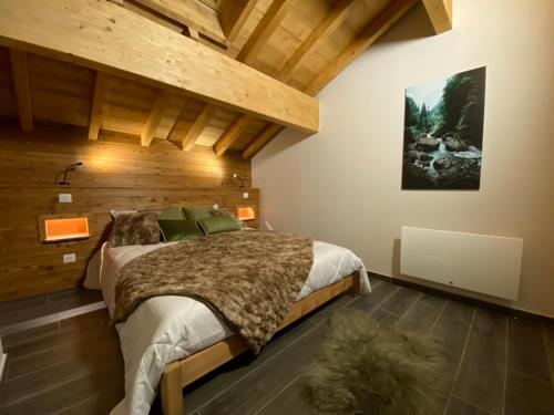- une chambre avec un grand lit et un plafond en bois dans l'établissement SUNWEB Chalet Mont Thabor, à La Toussuire