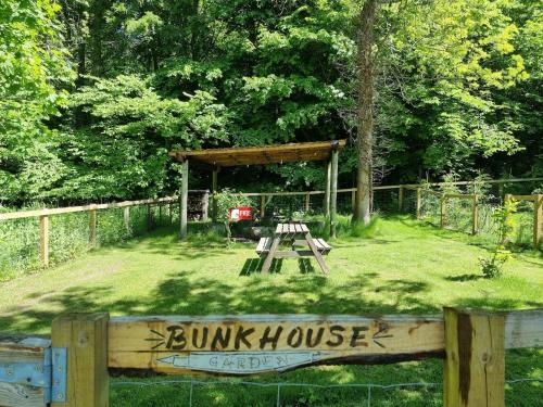 a wooden picnic shelter with a bench in the grass at Bunkhouse Northumberland in Preston