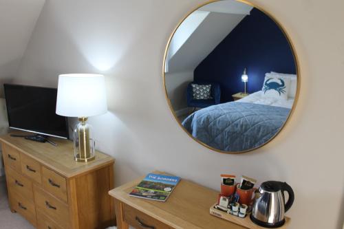 a bedroom with a bed and a mirror on the wall at The Old Buoy Inn in Seahouses