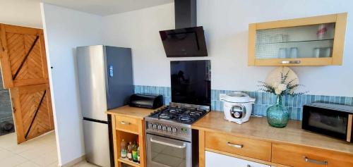 une cuisine avec une cuisinière et un réfrigérateur dans l'établissement L'abreuvoir de la Mer- villa - plage, à Sangatte