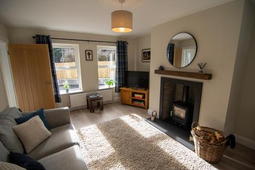 a living room with a couch and a fireplace at Crann Darach Cottages in Artikelly