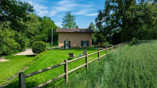 une petite maison dans un champ à côté d'une clôture dans l'établissement La Petite Maison Garde Barrière, à Baudrières